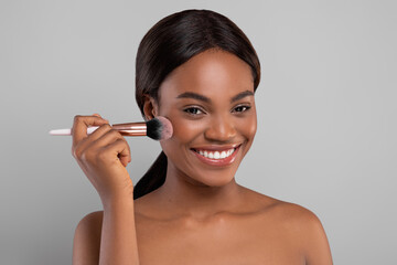 Closeup Portrait Of Attractive Happy Black Female Using Blusher Brush