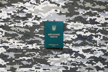 Ukrainian military ID on fabric with texture of pixeled camouflage. Cloth with camo pattern in...