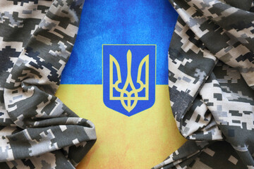 Ukrainian flag and coat of arms with fabric with texture of pixeled camouflage. Cloth with camo...