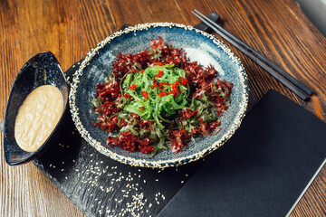 wakame seaweed salad with walnut sauce and sesame seeds in a plate