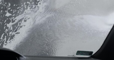 Auto detailer washes the car by foam from non-contact high pressure washer , 4k 60p Prores