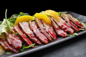 Sliced duck breast in caramel with oranges