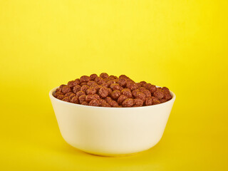 Chocolate Corn balls in bowl over yellow background