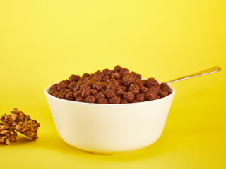 Chocolate Corn balls in bowl over yellow background