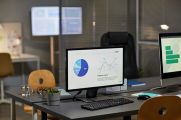 Background image of computer monitor in office with marketing charts, copy space