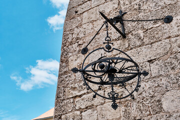 Metal astronomical sculpture hanging on old wall of Convent de San Francisco de Asis in Old Havana