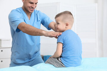 Fototapeta premium Orthopedist examining child in clinic. Scoliosis treatment