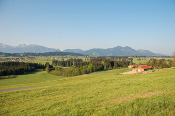 landschaft im allgäu, ostallgäu mit wiesen, häusern, bergen wäldern im sommer, panorama aussicht