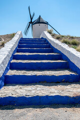 Access stairs to windmill in Consuegra, Toledo, Castilla La Mancha, Spain. Steps of intense blue lead to the entrance of the mill