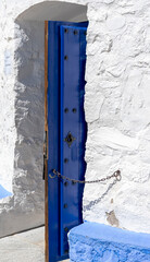 Access door to windmill in Consuegra, Toledo, Castilla La Mancha, Spain. A chain holds the intense blue door so that the wind does not close it