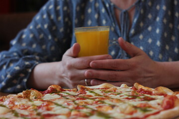 person holding a glass of orange juice