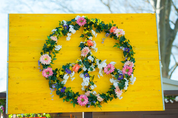 Peace sign, Peace symbol made of white daisies isolated on a yellow background. World peace, hippie concept, 60s, 70s, retro. Against World War, flower Peace sign
