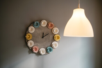 Wall clock with a dial made of cups. Coffee shop interior design idea