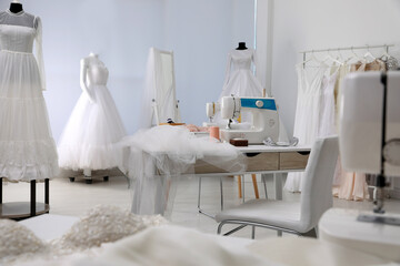 Dressmaking workshop interior with wedding dresses and equipment