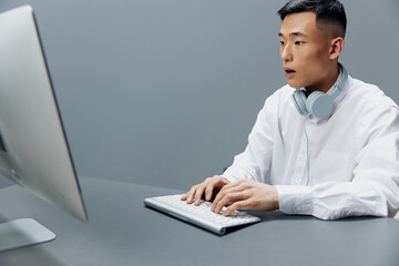 man in a white shirt with headphones sits in the office Lifestyle work
