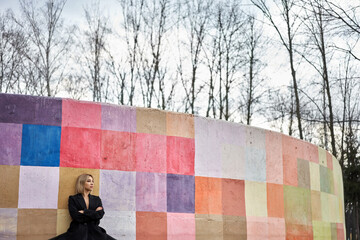 Blonde ballet dancer posing next to colorful wall