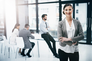 Teamwork and success go hand in hand. Portrait of an attractive young businesswoman standing in the boardroom during a meeting.