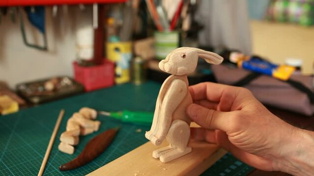 hare wooden toy in the hands of the master close-up