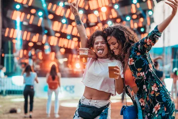 Fototapeten Two beautiful friends drinking beer and having fun on a music festival © Zamrznuti tonovi