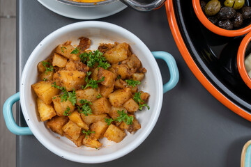 Cropped view of square sliced potato dish in pan, shot with selective focus from counter angle on breakfast background in isolated setting.