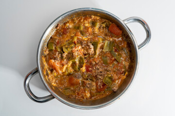 Close-up shot of classic Turkish traditional dish menemen dish, shot from overhead angle with selective focus on gray background, in isolated setting.