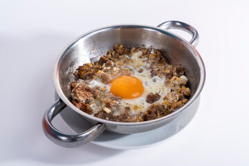 Close-up view of scrambled eggs in isolated setting, gray background with selective focus, from opposite or side angle.