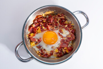 Close-up shot of eggs with bacon in isolated setting from top angle with selective focus on gray background.