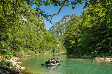 Group of unidentified tourists on a rafting boat on Tara river in Montenegro - obrazy, fototapety, plakaty