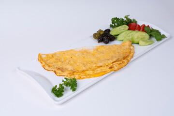 Cropped view of cucumber and tomato slices, olives and classic omelet on white plate, shot with selective focus from opposite or side view on isolated white background.