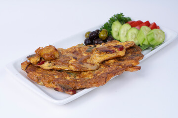 Cropped view of onion omelet with salad, olives and vegetables on white plate, shot in isolated area, gray background, with selective focus from opposite angle.
