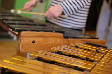 Close-up of the keys of a wooden percussion instrument and the hands of a playing musician selective focus of the background image musical concept