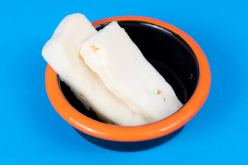 Cropped view of cheese plate shot from opposite or side angle with selective focus on isolated setting on blue background.