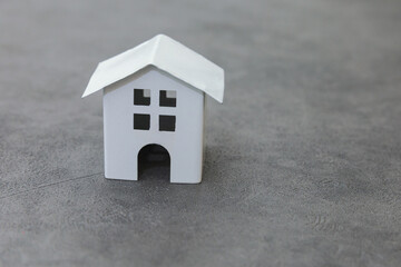 Obraz na płótnie Canvas Simply design with miniature white toy model house on concrete stone grey background. Mortgage property insurance dream home concept. Copy space.