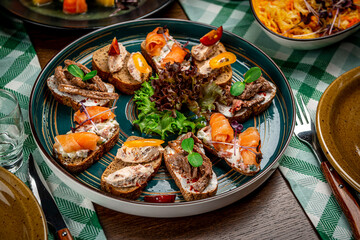 Set of bruschetta with roast beef, shrimps and salmon on dark wooden background
