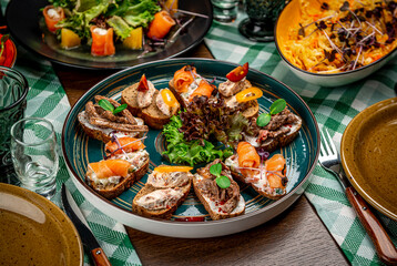 Set of bruschetta with roast beef, shrimps and salmon on dark wooden background