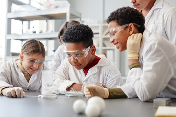 Portrait of African American boy enjoying enjoying science experiments in chemistry class and...