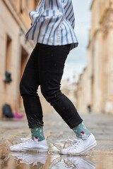 Woman's legs jumping into a puddle