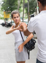 Girl outraged by touch on street and showing stop gesture