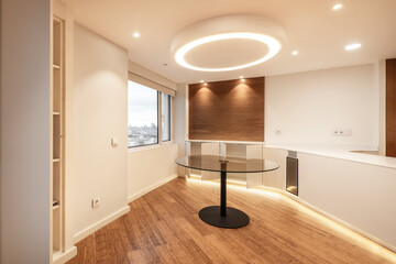 One story kitchen with white wood cabinets with white stone top in a study with large windows and oak parquet flooring