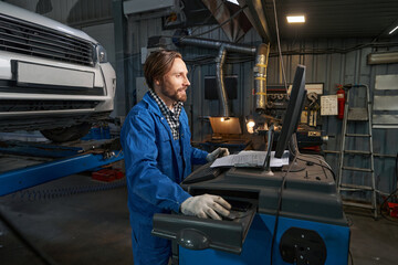 Portrait of man working at computer in service center