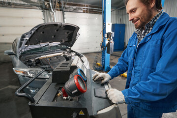 Mechanic working in service center and checking oil pressure