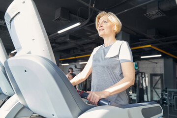 Cheerful woman doing cardio workout in gym