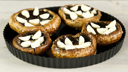 raw champignons stuffed with cheese, tomatoes and paprika in a baking dish. close up