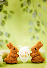 two brown easter bunnies are holding an easter egg with the text 