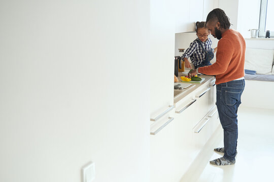 Caring male spending time in the kitchen with his daughter
