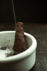 cigar in ashtray with smoke