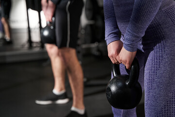 Fototapeta premium Close-up photo of female and man exercising in fitness club