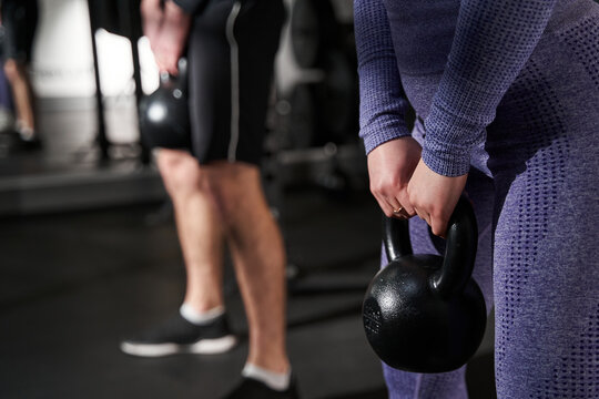 Close-up photo of female and man exercising in fitness club
