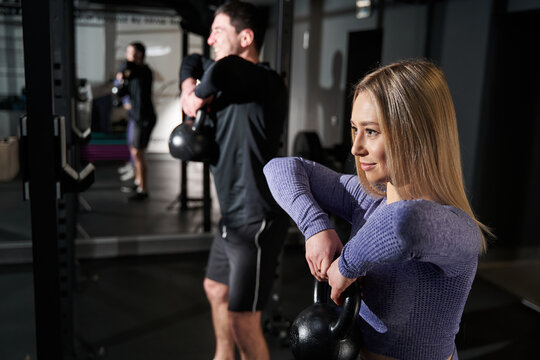 Close-up photo of woman and man exercising in fitness club