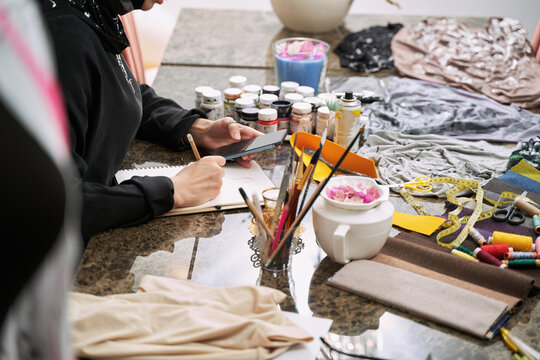 Creative muslim female making designer clothes in studio - Powered by Adobe
